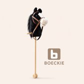 Zwart stokpaardje met bruine teugels en witte snuit op houten stok met wieltjes. Logo van BOECKIE.