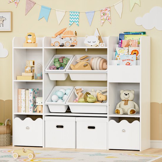 Een volle witte kinderopbergkast met boeken, speelgoed en manden in een kamer met slingers en een giraf poster.