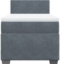 Lit boxspring gris foncé avec un matelas blanc et une tête de lit.