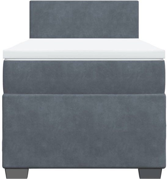 Lit boxspring gris foncé avec un matelas blanc et une tête de lit.