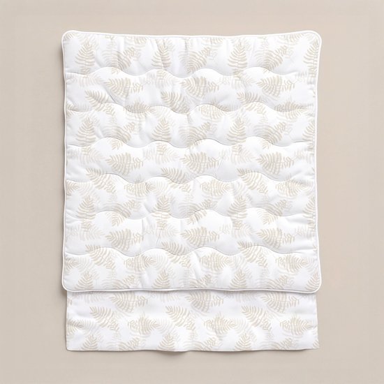 Wit dekbed met beige, herhalende bladmotieven en doorgestikte golven.
