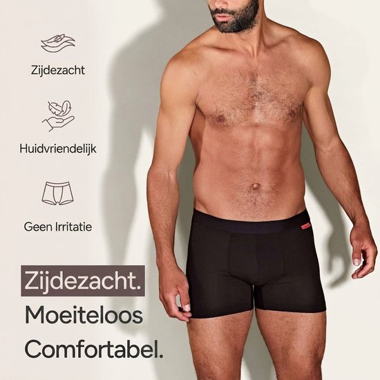 Man met baard, draagt zwarte boxer. Tekst: 'Zijdezacht. Moeiteloos Comfortabel.' Keurmerken: Zijdezacht, Huidvriendelijk, Geen Irritatie.
