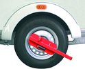 Rode DoubleLock compacte wielklem met sleutel op een witte trailerwiel.