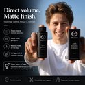 Man met blond haar houdt een zilverkleurige flacon en doosje met "Phoenix Hair Styling Powder" vast.