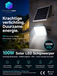 100W Solar LED schijnwerper met zonnepaneel, verlicht een muur bij nacht. Tekst: 'Krachtige verlichting. Duurzame energie.'