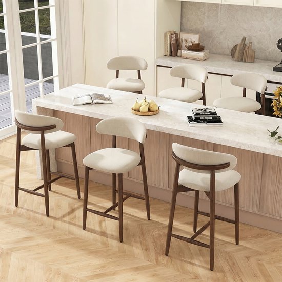Set van vijf beige barkrukken met houten poten en rugleuning bij een keukenbar.