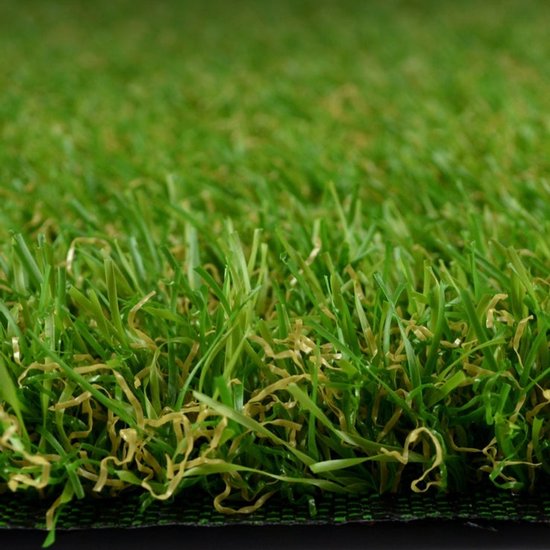 Gros plan de brins d'herbe artificielle verte avec quelques brins bruns.
