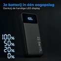 Zwarte powerbank met LED display dat 100% batterij toont, met percentages 0%, 20%, 50%, 100% ernaast.