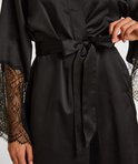Model strikt de zwarte satijnen kimono met ceintuur