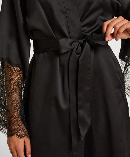 Model strikt de zwarte satijnen kimono met ceintuur