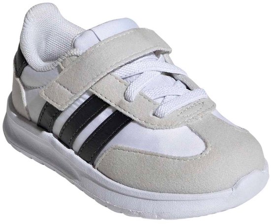 Witte kindersneaker met lichte grijze suède accenten, zwarte Adidas-strepen en klittenbandsluiting, van voren gezien.