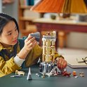 Une jeune fille construit une maquette LEGO de l'aile aux hiboux de Poudlard, avec des tourelles, des arches et des figurines de hiboux.