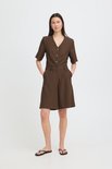 Model draagt een bruine culotte met korte mouwen en knopen.