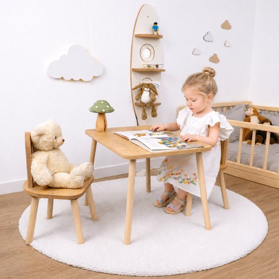 Houten kindertafel met twee stoelen, een meisje leest een boek aan tafel.