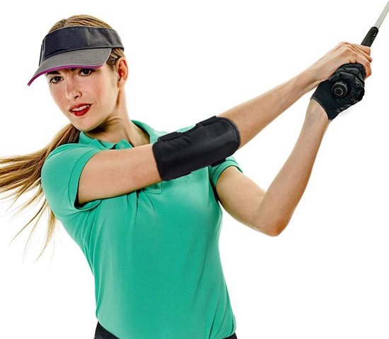 Vrouw in groene polo met zwarte golf elleboogbrace en pet, in een golfhouding.