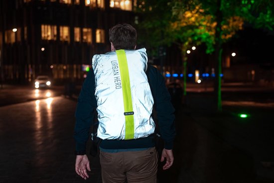 Homme de dos portant un sac argenté avec bande jaune et texte "URBAN HERO".