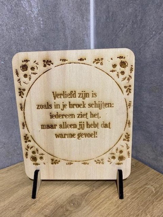 Plaque en bois avec texte : Être amoureux c'est comme chier dans son pantalon. Tout le monde le voit, mais seul vous avez cette sensation de chaleur. Avec bordure de fleurs.