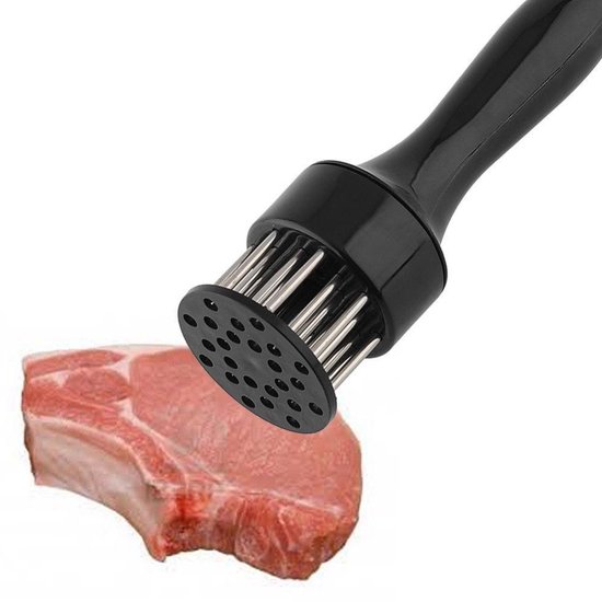 Attendrisseur à viande noir avec des broches en métal au-dessus d'un morceau de viande crue.