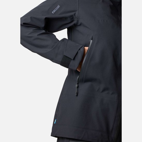 Dames met zwarte jas, met RECCO logo op de mouw en hand in de rits.