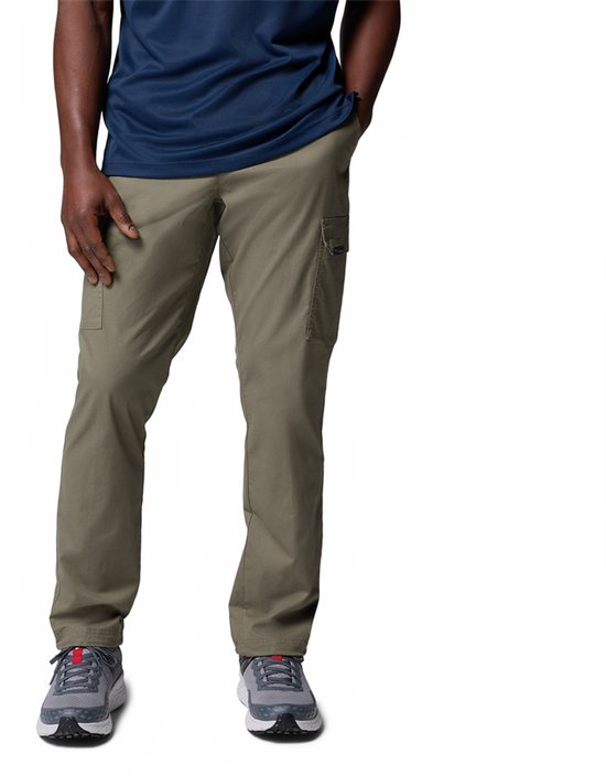 Homme portant un pantalon cargo beige avec des poches plaquées sur le côté des cuisses.