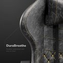 Zijkant van de rugleuning van een grijze gamestoel met gele stiksels. Gemaakt van 'DuraBreathe' materiaal.
