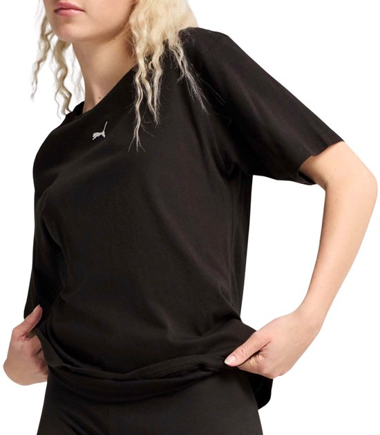 Een vrouw met blond haar draagt een zwarte Puma oversized T-shirt met een klein Puma logo op de borst.