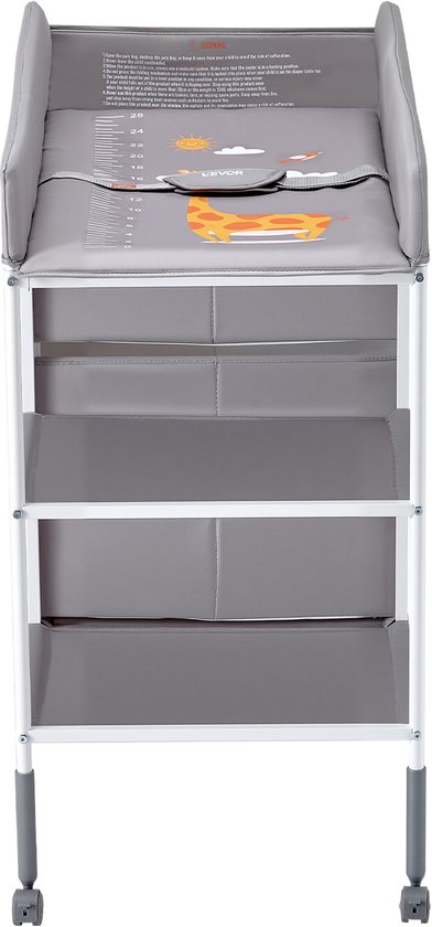 Grijze commode met luierkussen, opbergmanden, planken en wieltjes. Op het kussen staan afbeeldingen van een giraf en een vliegtuig.