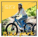 Meisje in een witte trui rijdt op een blauwe mountainbike in een bos, met de tekst "GKZ Bike park".