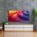 Een grote, randloze televisie met een levendige, abstracte kleurenafbeelding van oranje, roze en blauwe golven.