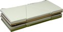 Opgevouwen foam mat met beige, lichtgroene en witte secties en ritsen.