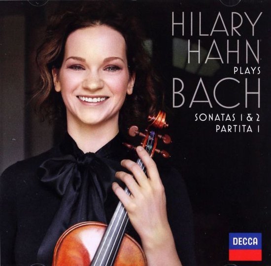 Hilary Hahn met viool, draagt zwarte strikblouse. Tekst: Hilary Hahn Plays Bach Sonatas 1 & 2 Partita 1.