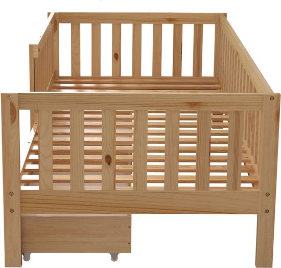 Houten ledikant met spijlen en een open lade aan de voorkant.