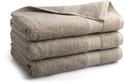 Stapel van drie beige badhanddoeken met een ribbelrand.