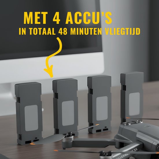 Vier grijze dronebatterijen staan op een houten tafel voor een monitor. Tekst: 'Met 4 accu's', 'In totaal 48 minuten vliegtijd'.