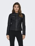 Vrouw met bruin haar in een zwarte faux leren bikerjack met rits middenvoor en ritszakken, zwarte broek.