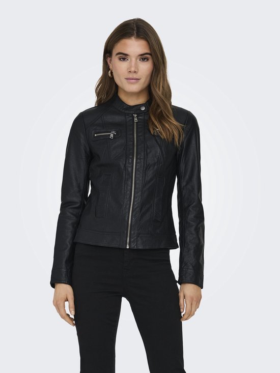 Vrouw met bruin haar in een zwarte faux leren bikerjack met rits middenvoor en ritszakken, zwarte broek.