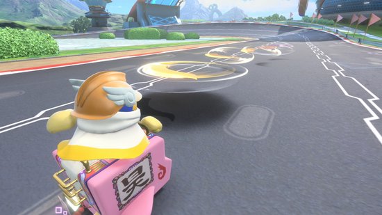 Een geel figuur met helm op een roze voertuig met Japanse tekens, rijdend op een racecircuit.