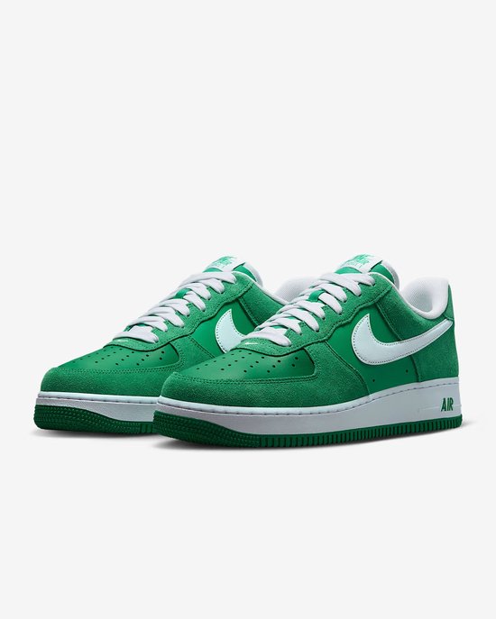 Paar groene Nike Air Force 1 sneakers met witte veters, witte swoosh en witte zool.