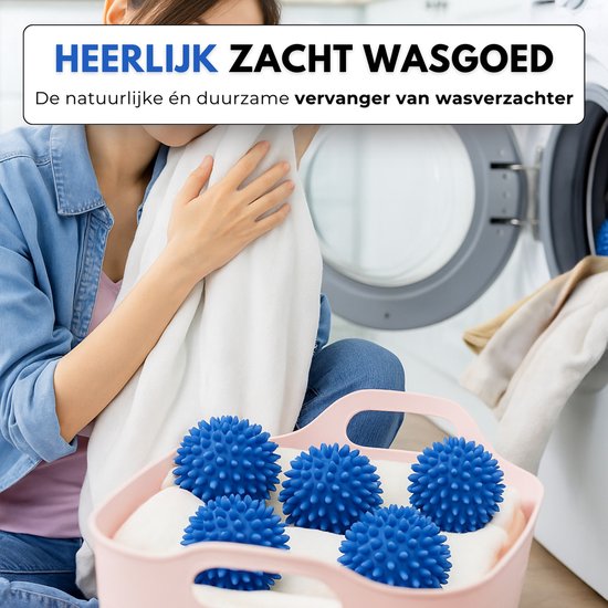 Une femme portant une veste en jean tient du linge doux, avec un panier plein de boules de séchage bleues à côté.