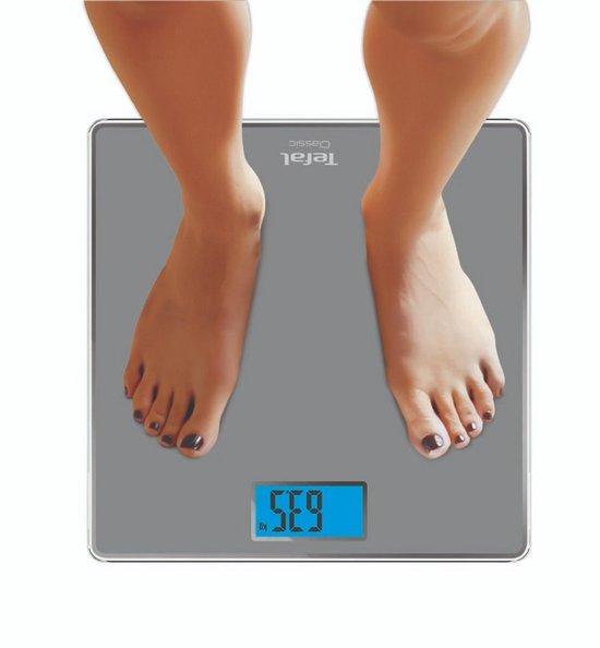 Pieds d'une personne sur une balance Tefal grise affichant 63,5 kg.