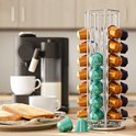 Zilverkleurige metalen capsulehouder met gouden, blauwe en paarse cups, in een keukenomgeving.