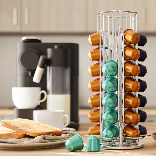 Zilverkleurige metalen capsulehouder met gouden, blauwe en paarse cups, in een keukenomgeving.