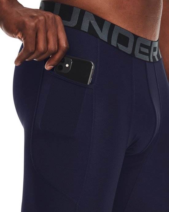 Donkerblauwe sportlegging met zijvak en een tailleband met de tekst UNDER ARMOUR.