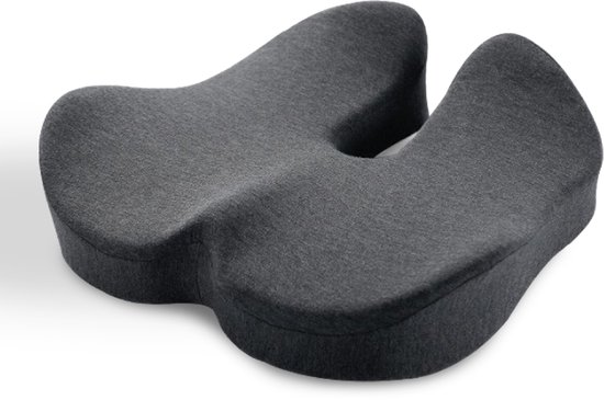 Een donkergrijs, U-vormig ergonomisch zitkussen met een uitsparing in het midden, liggend op een witte achtergrond.