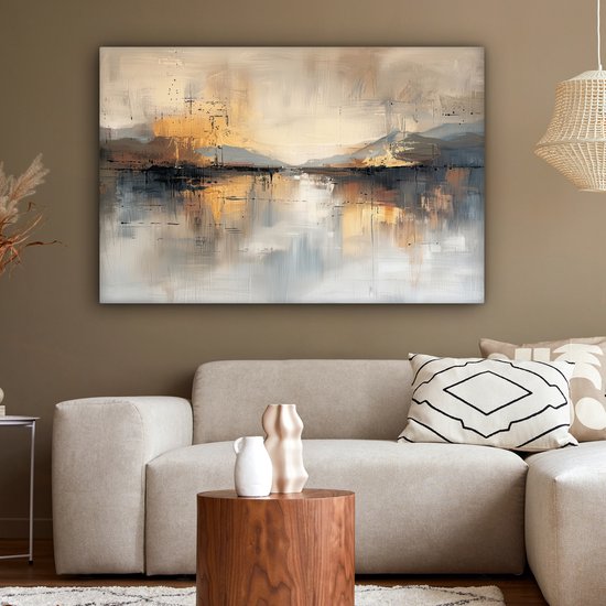Abstract schilderij met gouden, beige, grijze en zwarte tinten, hangend boven een bank in een woonkamer.