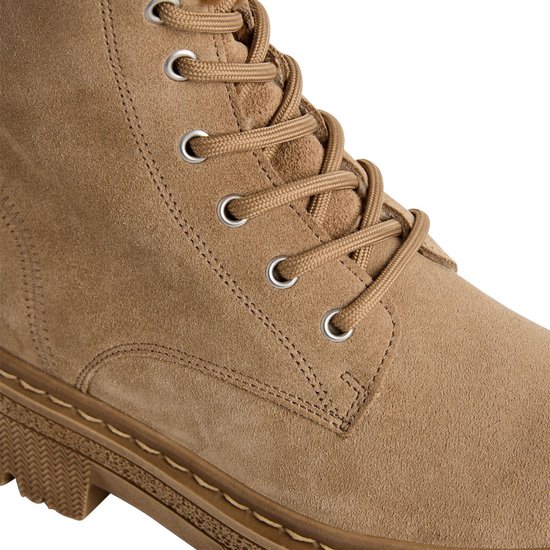 Detail van beige suède enkellaarsjes met veters, oogjes en profielzool.