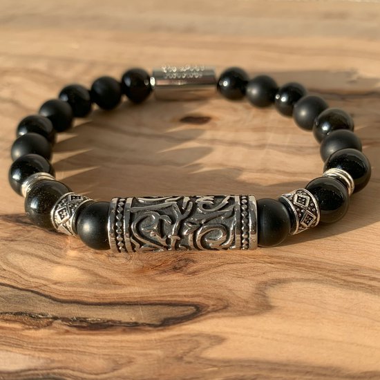 Zwarte armband met kralen van mat zwart en glanzend obsidiaan, zilverkleurige buis met gravures.