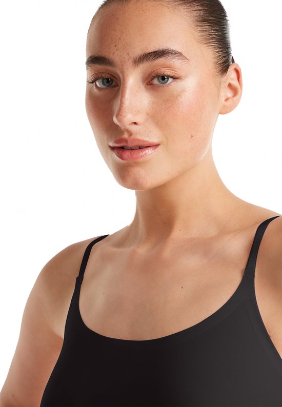 Close-up van een model met een zwarte spaghetti top van Ten Cate.