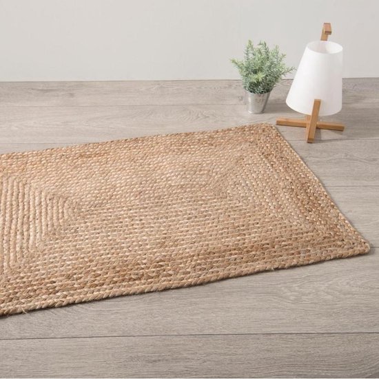 Beige gevlochten jute vloerkleed, op een houten vloer, met decoratie.