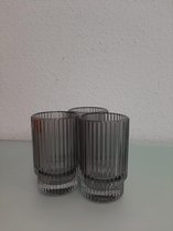 Drie glazen waxinelichtjeshouders met een patroon in het glas